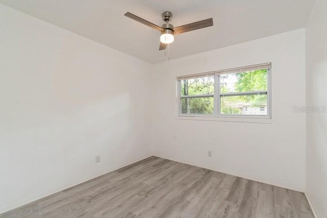 2911 NE 17th Ter, Gainesville, FL 32609 - empty room with light wood-style floors, a ceiling fan, and baseboards