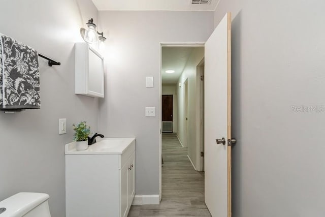 2911 NE 17th Ter, Gainesville, FL 32609 - bathroom with toilet, wood finished floors, vanity, and baseboards