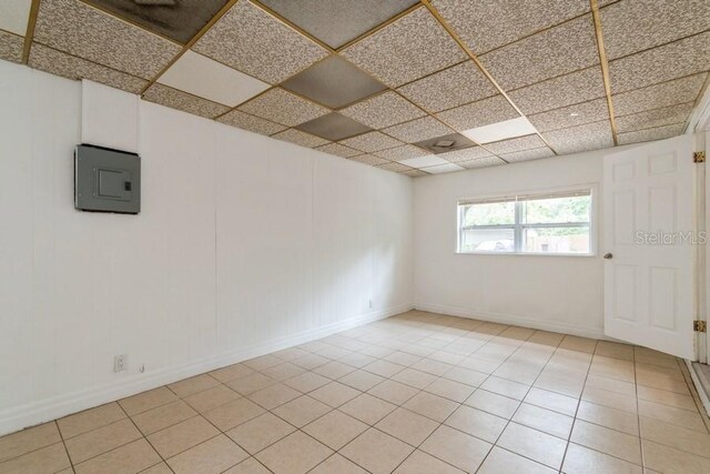 2911 NE 17th Ter, Gainesville, FL 32609 - spare room with a paneled ceiling, baseboards, light tile patterned flooring, and electric panel