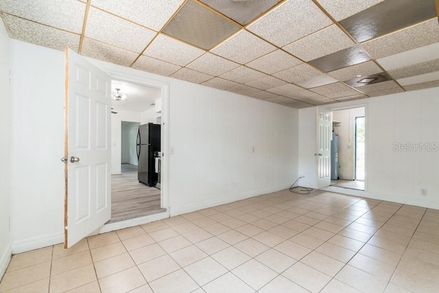 2911 NE 17th Ter, Gainesville, FL 32609 - empty room featuring a drop ceiling, light tile patterned floors, and baseboards