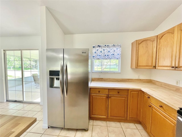 24409 NW 25th Pl, Newberry, FL 32669 - kitchen with stainless steel fridge, light tile patterned flooring, and vaulted ceiling