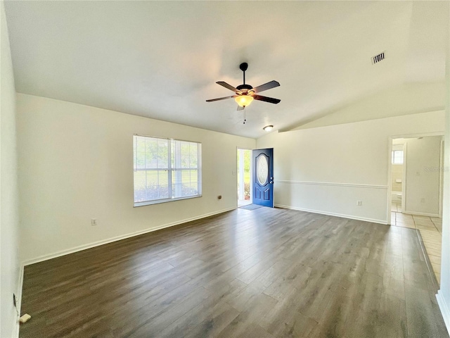 24409 NW 25th Pl, Newberry, FL 32669 - unfurnished living room featuring wood finished floors, a ceiling fan, healthy amount of natural light, vaulted ceiling, and baseboards