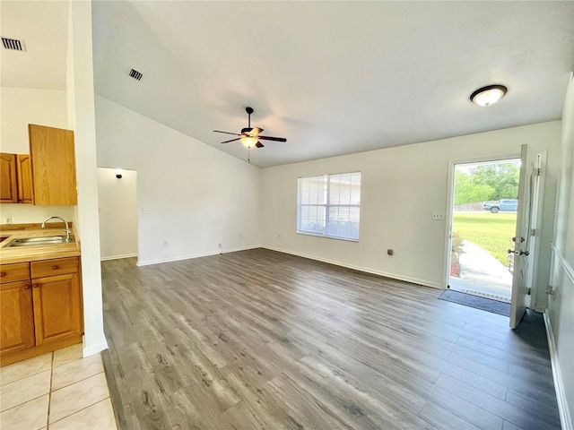 24409 NW 25th Pl, Newberry, FL 32669 - unfurnished living room featuring a sink, light wood-style flooring, ceiling fan, healthy amount of natural light, and vaulted ceiling