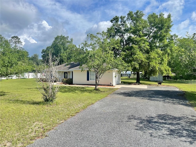 24409 NW 25th Pl, Newberry, FL 32669 - view of front of home with a front lawn, driveway, and solar panels