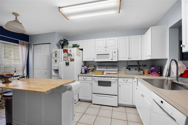 2636 SW 35th Pl Unit 21, Gainesville, FL 32608 - kitchen with white appliances, a sink, light tile patterned flooring, white cabinetry, and butcher block countertops