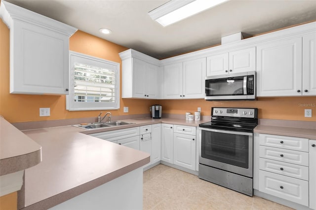 1979 NW 86th Ter, Gainesville, FL 32606 - kitchen with stainless steel appliances, a sink, white cabinets, recessed lighting, and light countertops