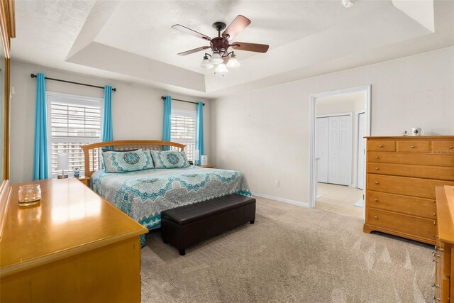 1979 NW 86th Ter, Gainesville, FL 32606 - bedroom featuring a tray ceiling, light colored carpet, baseboards, and a ceiling fan