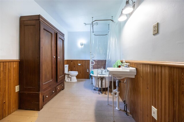 502 NE Cholokka Blvd, Micanopy, FL 32667 - full bathroom featuring a wainscoted wall, wood walls, a freestanding bath, toilet, and a shower