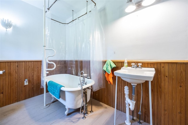 502 NE Cholokka Blvd, Micanopy, FL 32667 - full bathroom featuring wainscoting, a freestanding bath, wood finished floors, wood walls, and a shower with curtain