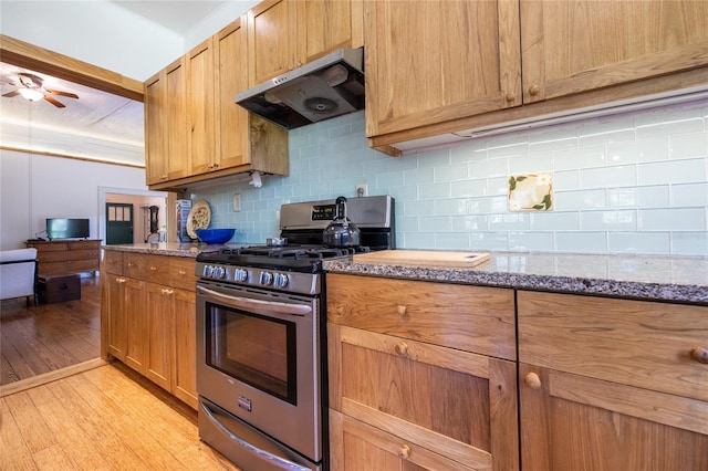 502 NE Cholokka Blvd, Micanopy, FL 32667 - kitchen featuring stainless steel gas stove, extractor fan, light wood finished floors, backsplash, and a ceiling fan