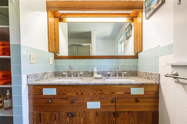 502 NE Cholokka Blvd, Micanopy, FL 32667 - full bathroom with tile walls, double vanity, a shower with shower door, and a wainscoted wall