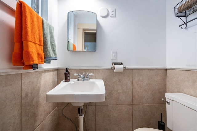 502 NE Cholokka Blvd, Micanopy, FL 32667 - bathroom featuring toilet, a wainscoted wall, and tile walls