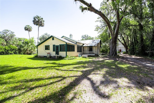 502 NE Cholokka Blvd, Micanopy, FL 32667 - back of house with a sunroom, a yard, and entry steps