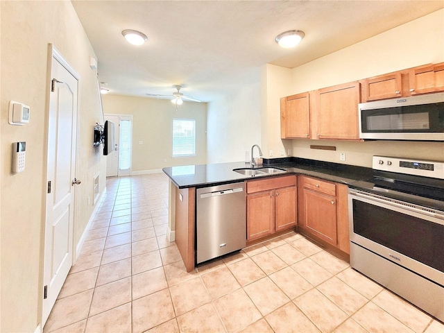 2964 SW 35th Pl Unit 75, Gainesville, FL 32608 - kitchen with appliances with stainless steel finishes, a sink, light tile patterned flooring, dark countertops, and a peninsula