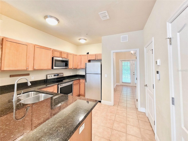 2964 SW 35th Pl Unit 75, Gainesville, FL 32608 - kitchen with appliances with stainless steel finishes, a sink, light brown cabinets, light tile patterned floors, and dark stone counters