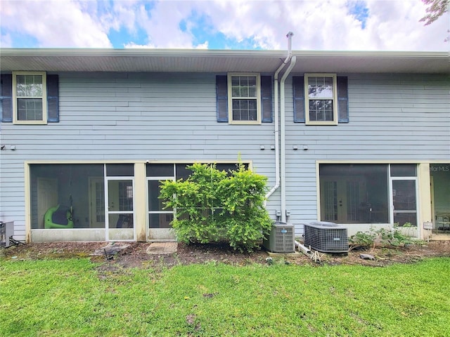 2964 SW 35th Pl Unit 75, Gainesville, FL 32608 - rear view of house featuring a sunroom, central AC, and a lawn