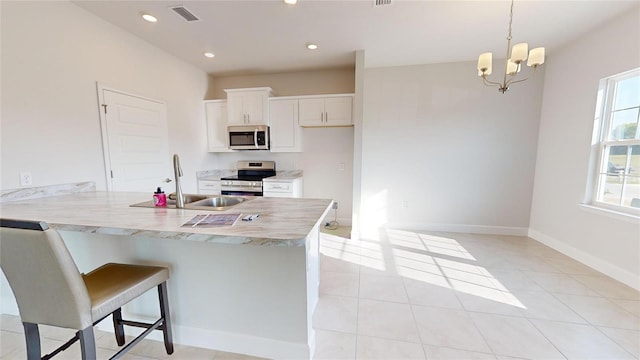 3279 E Iris Ln, Bell, FL 32619 - kitchen with stainless steel appliances, a sink, white cabinets, light countertops, and a peninsula