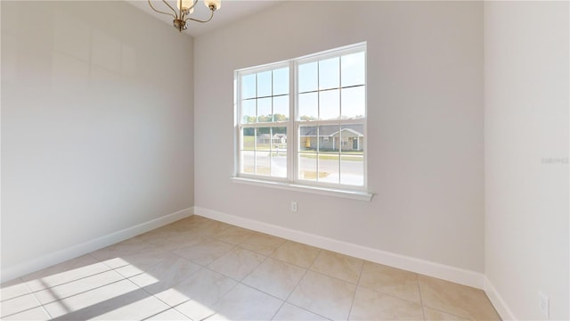 3279 E Iris Ln, Bell, FL 32619 - empty room featuring light tile patterned floors, baseboards, and a chandelier