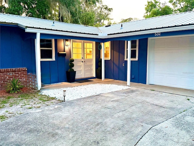 532 NE 7th Ter, Gainesville, FL 32601 - view of exterior entry with board and batten siding, a garage, and metal roof