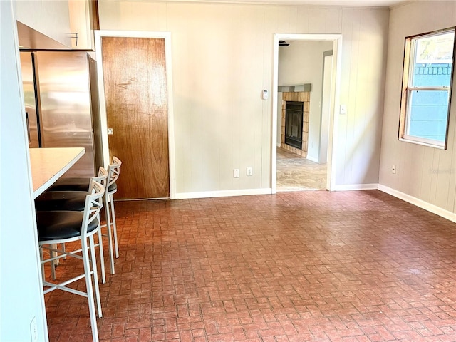 532 NE 7th Ter, Gainesville, FL 32601 - unfurnished dining area with brick patterned flooring, a tile fireplace, and baseboards