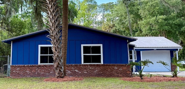 532 NE 7th Ter, Gainesville, FL 32601 - view of front of house featuring board and batten siding, an attached garage, driveway, and brick siding