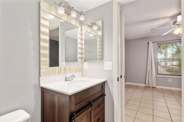 2360 SW Archer Rd Unit 1102, Gainesville, FL 32608 - half bath featuring ceiling fan, tile patterned floors, vanity, toilet, and baseboards