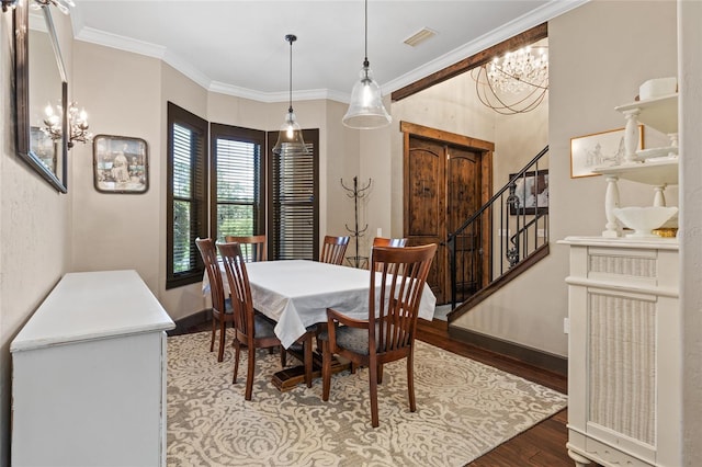 dining area with a chandelier, wood finished floors, crown molding, baseboards, and stairs