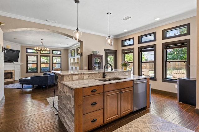 kitchen featuring a sink, dishwasher, brown cabinetry, open floor plan, and dark wood-style floors