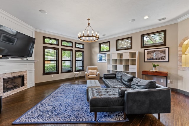 living room featuring crown molding, a chandelier, wood finished floors, baseboards, and a fireplace