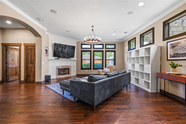 living area featuring wood finished floors, arched walkways, ornamental molding, a fireplace, and recessed lighting