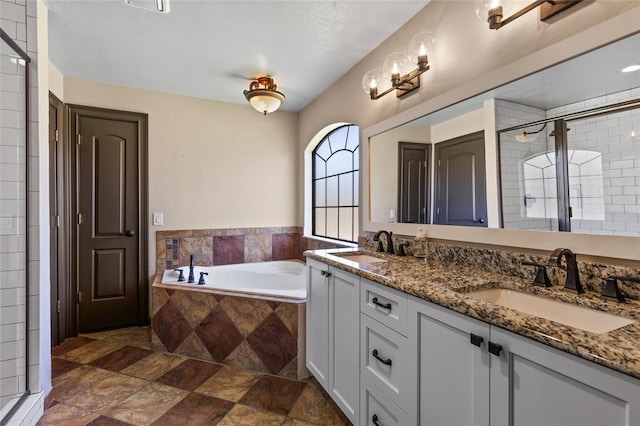 bathroom featuring stone finish floors, a garden tub, a shower stall, and double vanity