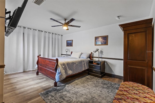 bedroom with wood finished floors, baseboards, and a ceiling fan
