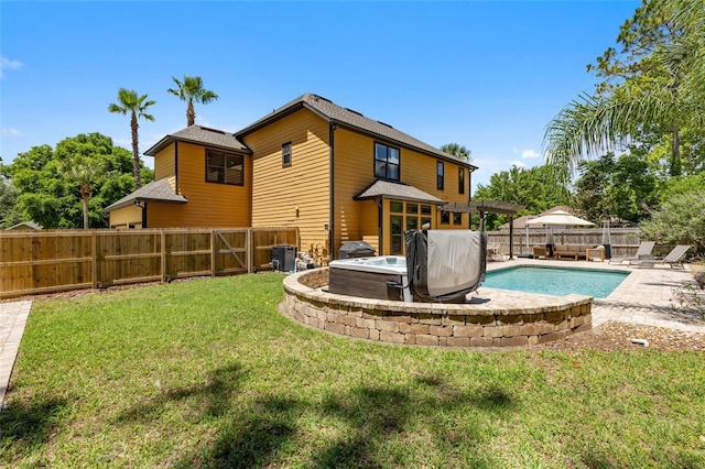 back of house featuring a hot tub, a patio area, and cooling unit