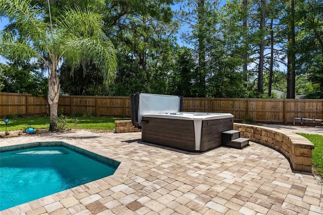 view of swimming pool featuring a hot tub, a patio, and a fenced backyard