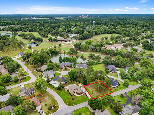 aerial perspective of suburban area featuring a nearby body of water, property boundaries highlighted, and a forest