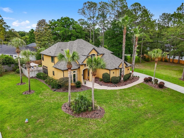 traditional home with a shingled roof, stucco siding, and view of wooded area