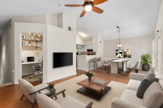 10000 SW 52nd Ave Unit J50, Gainesville, FL 32608 - living room with vaulted ceiling, wood finished floors, a desk, and ceiling fan