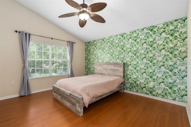10000 SW 52nd Ave Unit J50, Gainesville, FL 32608 - bedroom with wallpapered walls, baseboards, lofted ceiling, wood finished floors, and an accent wall