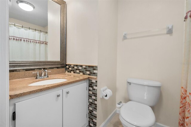 10000 SW 52nd Ave Unit J50, Gainesville, FL 32608 - full bathroom featuring baseboards, toilet, vanity, tasteful backsplash, and tile patterned flooring
