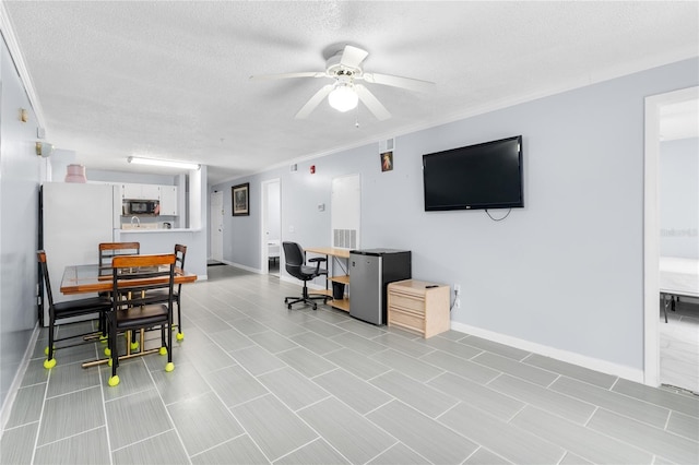 office with a ceiling fan, a textured ceiling, and baseboards