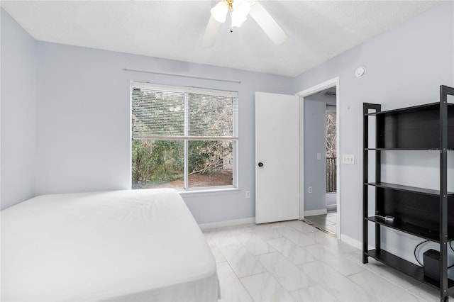 bedroom featuring baseboards, ceiling fan, and light marble finish floors
