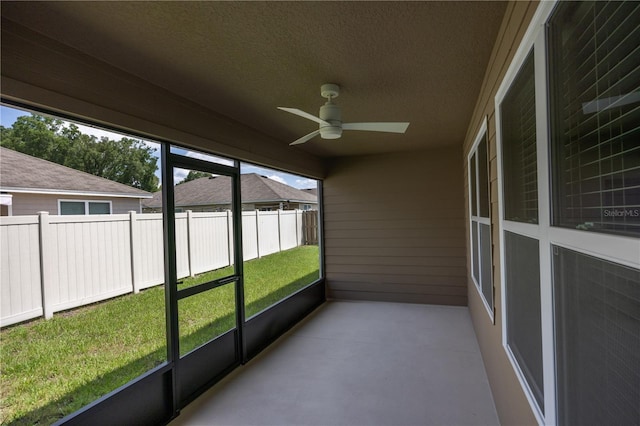 unfurnished sunroom with a ceiling fan