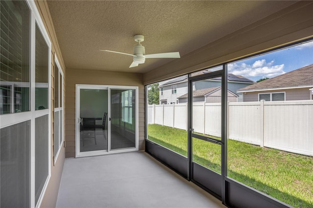 unfurnished sunroom with ceiling fan