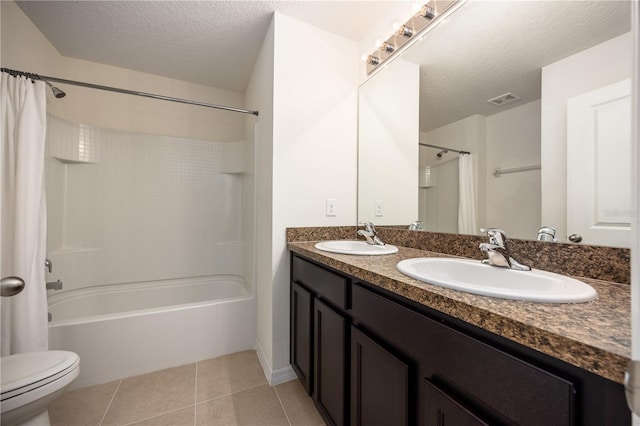 bathroom with shower / bath combo, toilet, a textured ceiling, tile patterned flooring, and double vanity