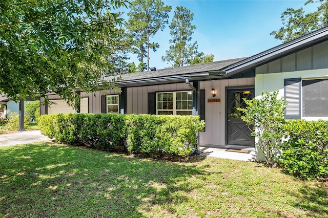 5610 NW 29th Ter, Gainesville, FL 32653 - entrance to property with a yard, board and batten siding, concrete driveway, and an attached garage