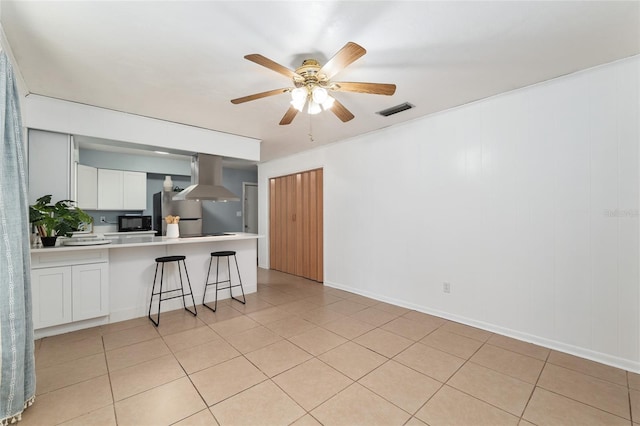 5610 NW 29th Ter, Gainesville, FL 32653 - kitchen with island range hood, freestanding refrigerator, a peninsula, light countertops, and a kitchen bar