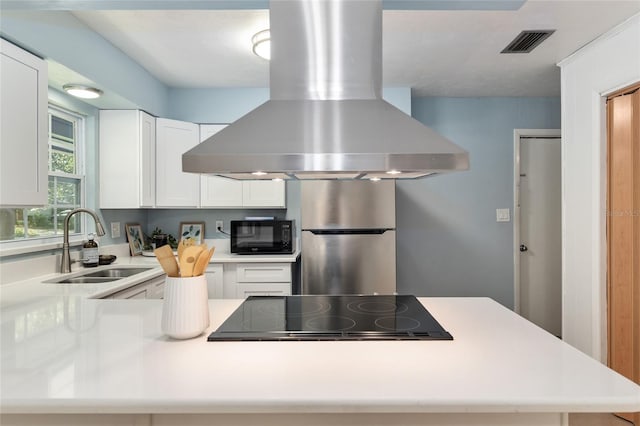 5610 NW 29th Ter, Gainesville, FL 32653 - kitchen featuring island exhaust hood, black appliances, light countertops, white cabinetry, and a peninsula