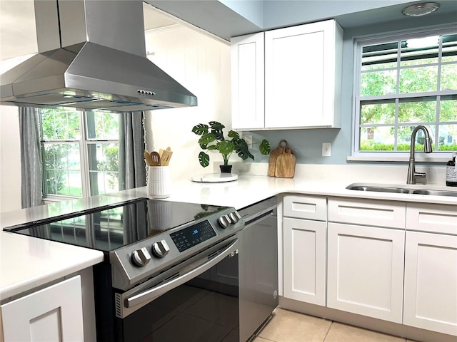 5610 NW 29th Ter, Gainesville, FL 32653 - kitchen with range hood, electric range, light countertops, white cabinetry, and light tile patterned floors