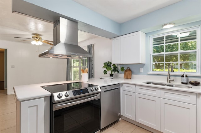 5610 NW 29th Ter, Gainesville, FL 32653 - kitchen with appliances with stainless steel finishes, island range hood, a peninsula, light tile patterned flooring, and a ceiling fan