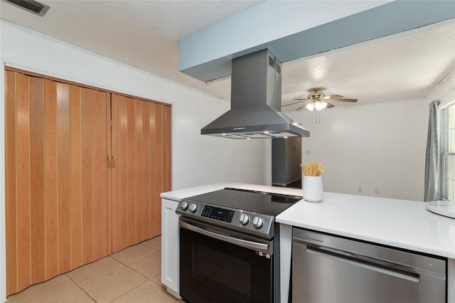 5610 NW 29th Ter, Gainesville, FL 32653 - kitchen with appliances with stainless steel finishes, island exhaust hood, ceiling fan, light tile patterned floors, and light countertops